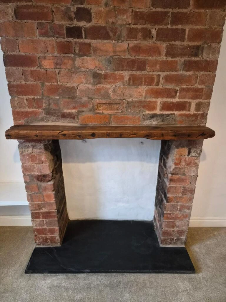 Living room view of exposed brick fireplace